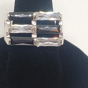 STAINLESS SIZE 7 RING WITH 6 BLACK AND CLEAR BAGGETTE SET STONES.